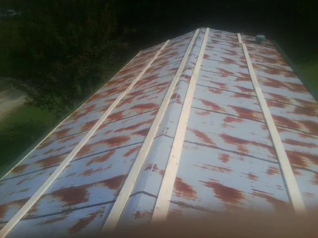 Rusted metal roof panels with new wood purlins before replacement — Storm Damage Roof Repair in Calhan by Roofing Brothers
