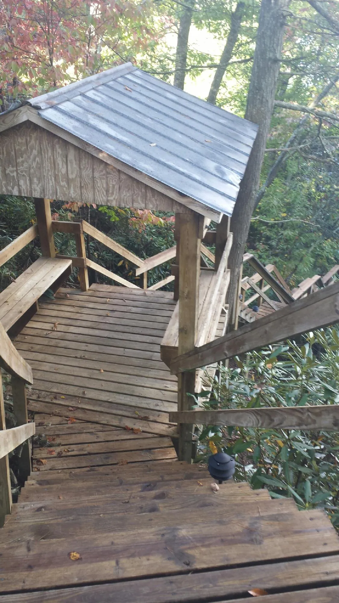 Metal roofed shelter over wooden steps on a wooded walkway — Skylight Repair & Installation work by our crew in Calhan