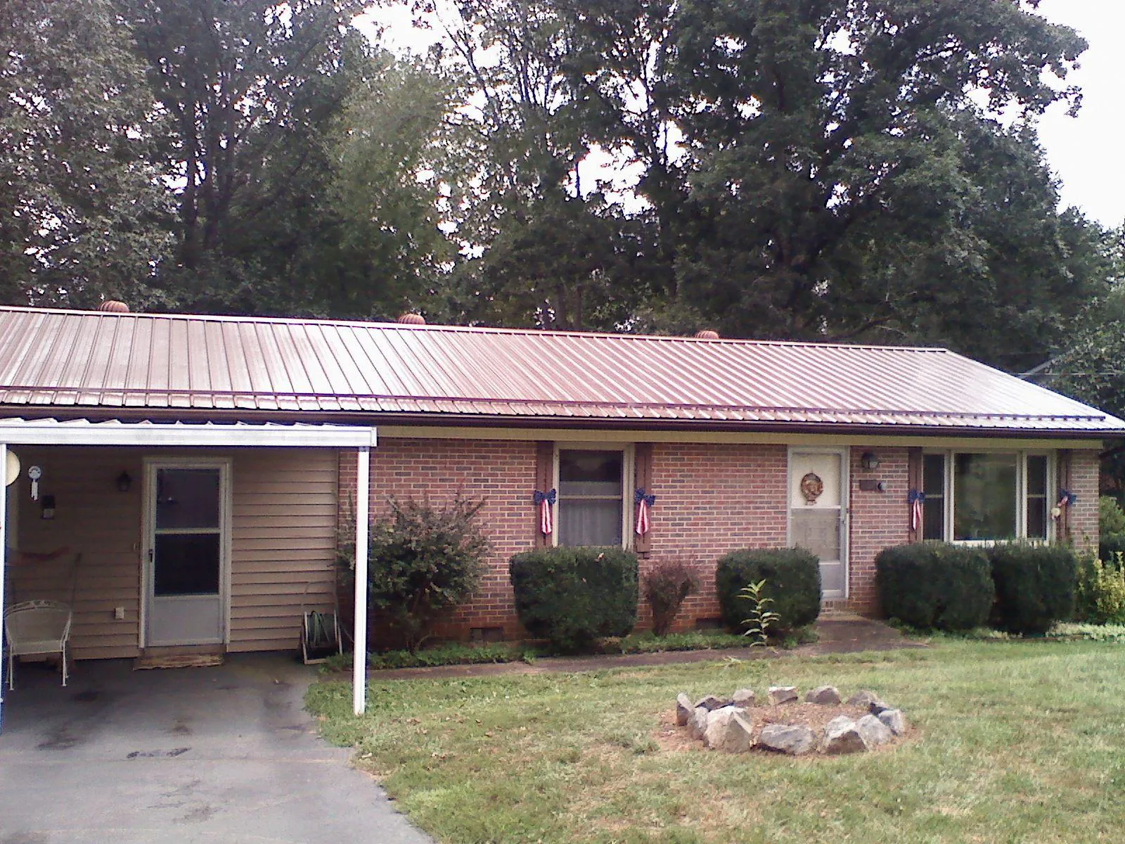 Bronze metal roof and carport on a brick ranch home — Roof Repair work by our crew in Calhan